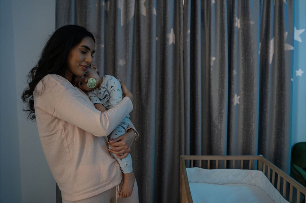 Mother cuddling her baby at night, creating a soothing and comforting bedtime routine